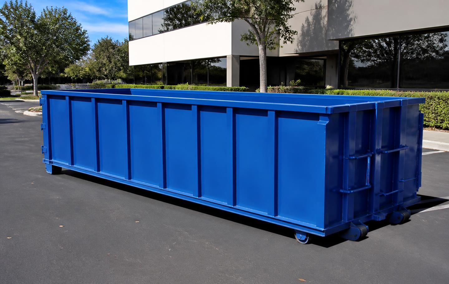 Blue open-top roll-off container in a commercial office park parking lot