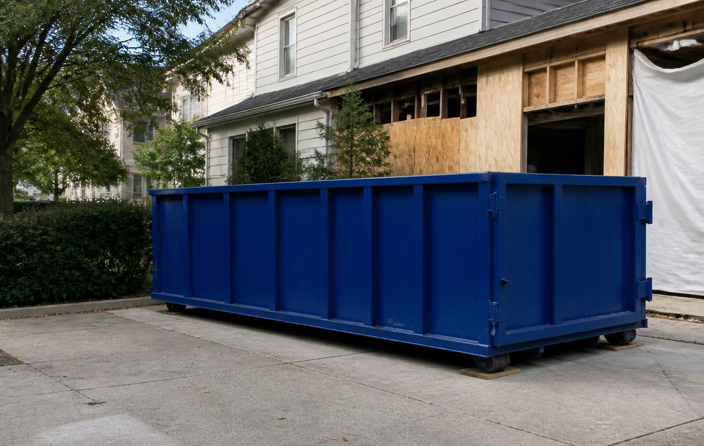 Clean empty roll-off dumpster temporarily placed at a house under renovation